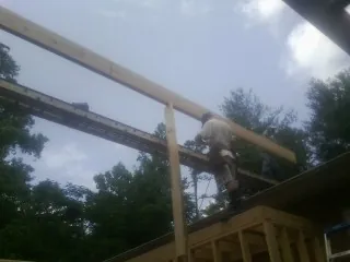 Carpenter setting a ridge beam over a new addition frame — Ice Dam Removal by Roofing Brothers in Half Moon Bay