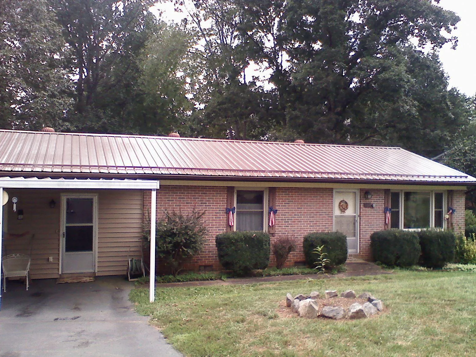 Bronze metal roof and carport on a brick ranch home — Roof Repair work by our crew in Half Moon Bay
